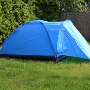 a blue tent in a grassy area