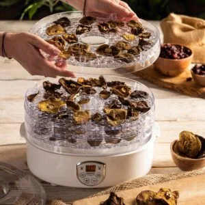 a person holding a tray of dried mushrooms